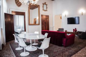 ein Wohnzimmer mit einem Tisch und einem roten Sofa in der Unterkunft Cà Mascaròn in Venedig