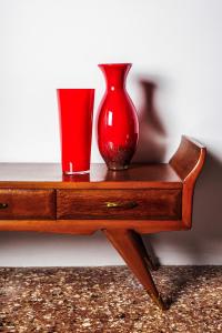 a red vase and a cup on a wooden table at Cà Mascaròn in Venice