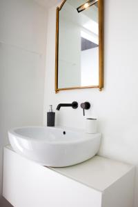 ein weißes Waschbecken im Bad mit Spiegel in der Unterkunft Cà Mascaròn in Venedig
