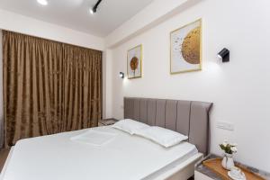 a bedroom with a white bed and a window at New Saburtalo Apartment in Tbilisi City