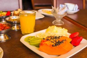 einen Obstteller auf einem Tisch mit einem Glas Orangensaft in der Unterkunft Hotel Verde Plaza in Santana do Livramento