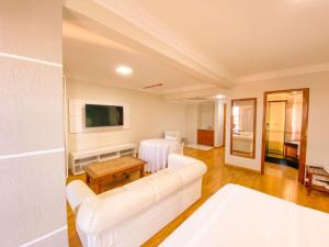 uma sala de estar com um sofá branco e uma mesa em Hotel Verde Plaza em Santana do Livramento