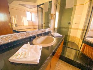 a bathroom with a sink and a mirror at Hotel Verde Plaza in Santana do Livramento