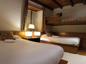 1 dormitorio con 2 camas y 1 litera en AC Apartaments Tarter Chalet en El Tarter