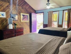 1 dormitorio con 2 camas y puerta morada en Reef House Resort, en Oak Ridge