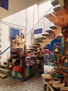una tienda con una escalera y estanterías de zapatos en Apartamento Queen Centro Histórico - Vila Ilhabela, en Ilhabela