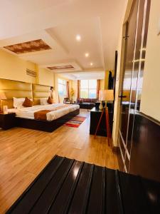 a bedroom with a bed in a room with wooden floors at Reo Resort, near bus stand & railway station ,Haridwar in Haridwār