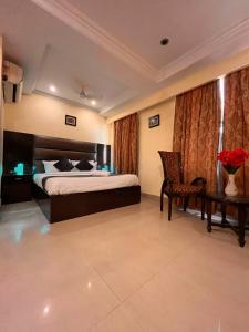 una camera d'albergo con letto e sedia di Reo Resort, near bus stand & railway station ,Haridwar a Haridwār