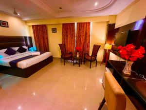 a hotel room with a bed and a table and chairs at Reo Resort, near bus stand & railway station ,Haridwar in Haridwār