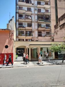 um grupo de pessoas andando por uma rua em frente a um edifício em Dpto céntrico con estacionamiento em San Miguel de Tucumán