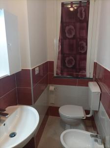 a bathroom with a white toilet and a sink at Valery AffittaCamere in Capannori