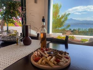 a plate of food on a table with a bottle of wine at Nisea Hotel Samos in Pythagoreio +37 photos