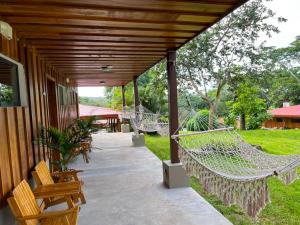 een veranda met hangmatten in een huis bij Hacienda Guachipelin Volcano Ranch Hotel & Hot Springs in Liberia
