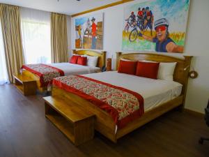 ein Hotelzimmer mit 2 Betten und einem Gemälde an der Wand in der Unterkunft Hacienda Guachipelin Volcano Ranch Hotel & Hot Springs in Liberia