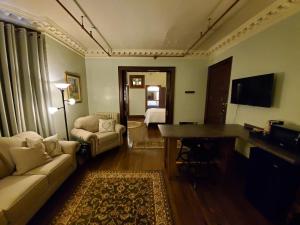 un soggiorno con divano e scrivania in una camera di Daniell Manor a Laurium