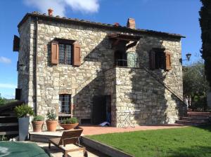 a stone house with a bench in front of it at Casale La Petrosa in Radda in Chianti