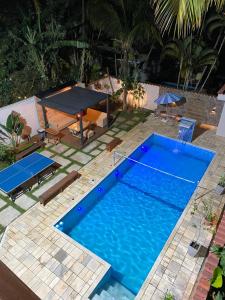 an overhead view of a pool with a table and a tennis court at Morada do Sol. in São Sebastião