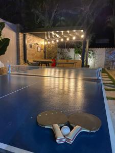 a skateboard and two balls on a ping pong table at Morada do Sol. in São Sebastião