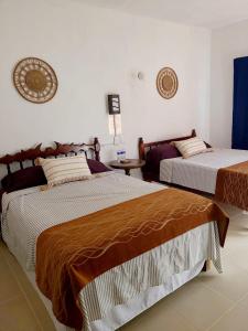 1 dormitorio con 2 camas y mesa en Casa Terracota en Bacalar