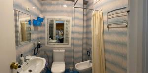 une salle de bain avec un lavabo, des toilettes et un miroir dans l'établissement Casa Maria, à Estepona 6 autres photos
