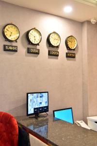 a room with clocks on the wall and a desk at Imperial Suites in Lahore