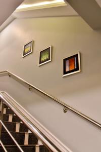 three framed paintings on the wall of a stair case at Imperial Suites in Lahore