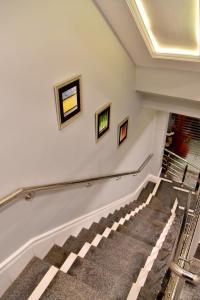 a set of stairs in a building with paintings on the wall at Imperial Suites in Lahore