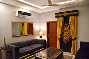 ein Wohnzimmer mit einem Sofa und einem Spiegel in der Unterkunft Imperial Suites in Lahore