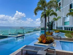 an infinity pool at a hotel with a view of the ocean at Cloc Marina Vista Mar p/ a Baía de Todos os Santos in Salvador