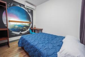 1 dormitorio con 1 cama con una pintura en la pared en Hotel Sirius Costa Rica en San Mateo
