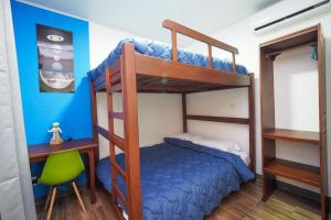 a bedroom with bunk beds with a desk and a chair at Hotel Sirius Costa Rica in San Mateo