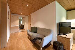 ein Wohnzimmer mit einem Sofa und einem Flachbild-TV in der Unterkunft Ferienwohnungen Lingg in Schoppernau