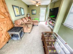 a living room with a couch and a flat screen tv at The FARM House in New Braunfels