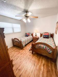 新布朗費爾斯的住宿－The Comal River Escape，一间卧室配有两张床和吊扇