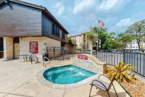 a swimming pool with chairs and a fence at Restful River Retreat in New Braunfels