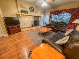 a living room with a couch and a flat screen tv at Restful River Retreat in New Braunfels