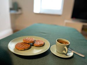 due ciambelle e una tazza di caffè sul tavolo di Gwandalan - 1 Bed Apartment, Within Tenby Town Walls a Tenby