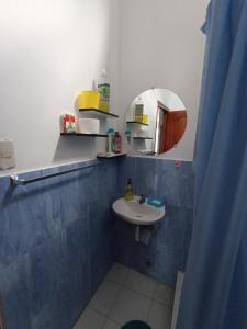 ein Bad mit einem Waschbecken und einem Spiegel in der Unterkunft Departamento familiar en Manta in Manta