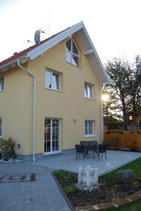 une maison jaune avec une table et des bancs devant elle dans l'établissement Appartement Florian, à Vienne
