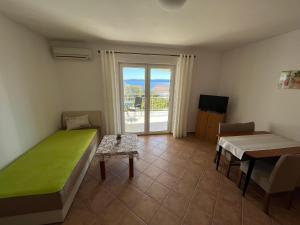 um quarto com uma cama, uma mesa e uma janela em Apartmani Emil em Trogir