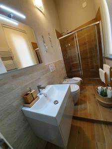 a bathroom with a sink and a toilet and a mirror at La Dimora di via Trieste in Civitanova Marche