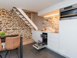 a kitchen and dining room with a stone wall at Tiny Fox Kluisbos in Mont-de-l'Enclus