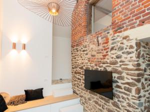 uma sala de estar com uma parede de tijolos e uma televisão em Tiny Fox Kluisbos em Orlitain