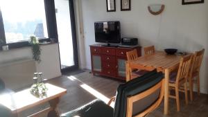 a living room with a table and a television and a table and chairs at Niedersfeld Polzweg in Winterberg +10 photos
