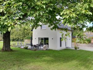 una casa blanca con un árbol en el patio en gîte les bouleaux, en Carspach