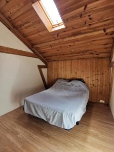 Cama en habitación con techo de madera en Terre Rouge en Boulc