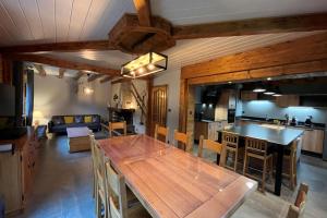 uma cozinha e sala de estar com uma mesa de jantar em madeira em House type chalet - sauna and balneo - 14 pers em Gérardmer