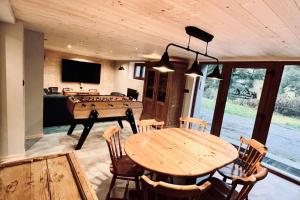 uma sala de jantar com uma mesa e uma mesa de pingue-pongue em House type chalet - sauna and balneo - 14 pers em Gérardmer