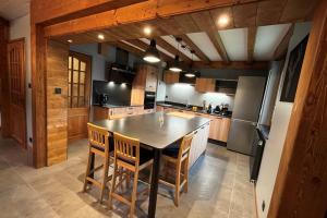 a kitchen with a table and chairs and a refrigerator at House type chalet - sauna and balneo - 14 pers in Gérardmer
