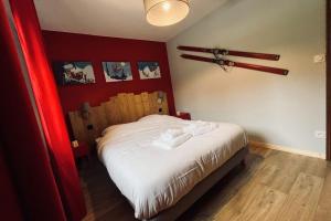 a bedroom with a bed with a red wall at House type chalet - sauna and balneo - 14 pers in Gérardmer +21 photos